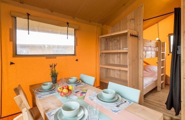 Een gedekte tafel in de woonkamer waaraan gegeten kan worden in de mooiste safaritent van Nederland